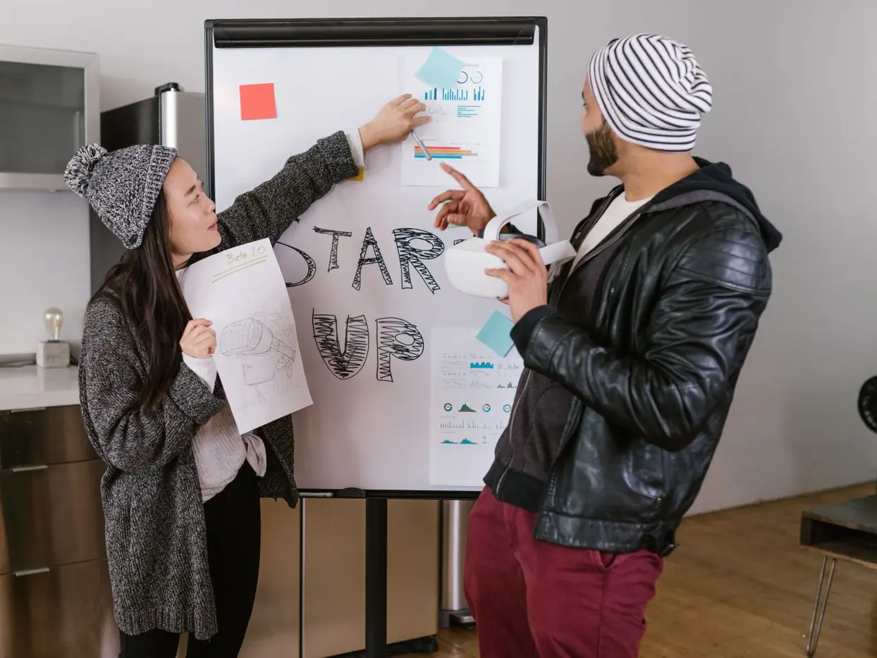 Two young adults sketching out a startup idea on a flipchart