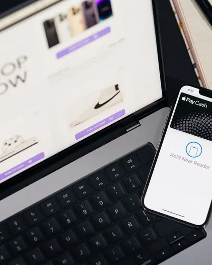 An online store checkout on a laptop beside a phone ready to pay