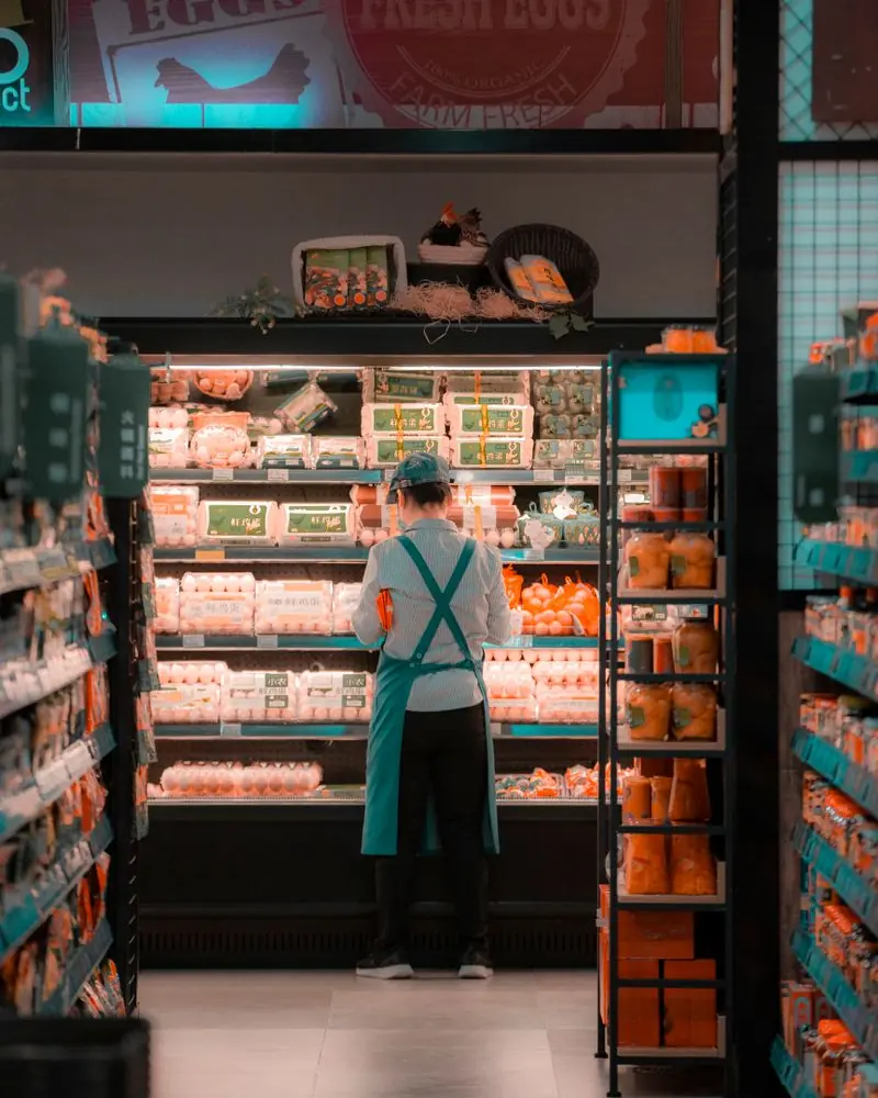 A store worker stocking shelves in a grocery aisle
