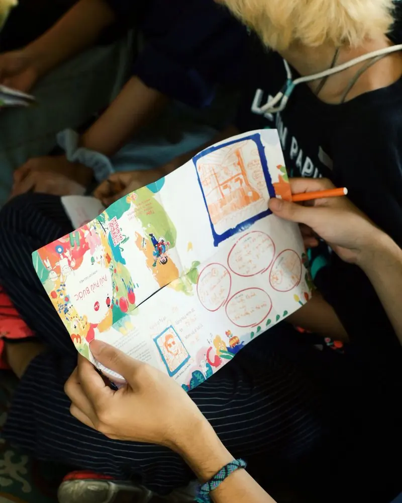 Teenagers coloring a hand-drawn poster together